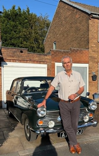 Eddie Foster standing proudly beside his classic car