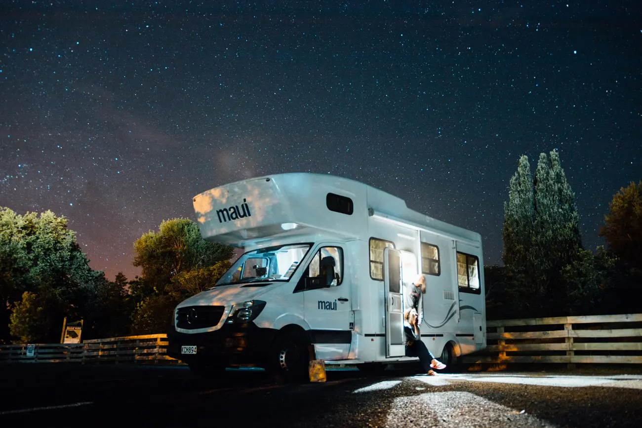 A motorhome parked at a campsite at night